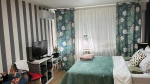 a bedroom with a bed and a television in it at Studio 5 apartman in Kragujevac