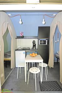 Il comprend une cuisine avec une table, des chaises et une table. dans l'établissement Camping Larribal, à Millau