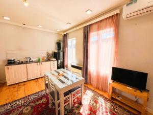a living room with a television and a kitchen at "STAIRS"guest house in Yerevan
