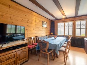a dining room with a table and chairs and a television at Quietly situated group house in the southern Black Forest with a gorgeous view in Todtmoos