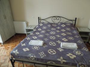 a bed with a purple comforter with two pillows at azahostel in K'obulet'i