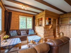 a living room with leather furniture in a log cabin at Quietly situated group house in the southern Black Forest with a gorgeous view in Todtmoos