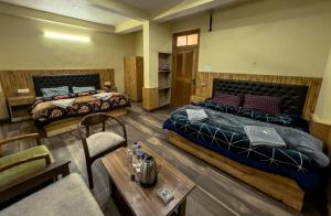 a hotel room with two beds and a table at Delhi Height Kasol - Cafe and Hotel in Kasol