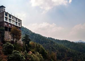 un edificio sul fianco di una montagna di Goroomgo Divine Hills Shimla -Natural Landscape & Mountain View - With Parking Facilities a Shimla