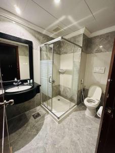 a bathroom with a shower and a toilet and a sink at Jawharet Al Majd Hotel in Mecca