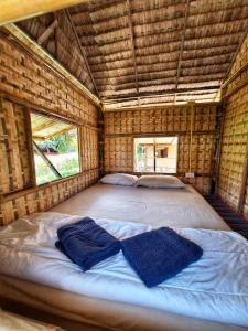 Cama grande en habitación de bambú con 2 almohadas en Samui Camping Farm en Laem Sor