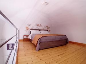 a bedroom with a bed and a wooden floor at Ognina Marina Gem in Catania