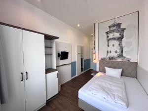 a bedroom with a bed and a picture of a lighthouse at Hotel Rummeni in Borkum