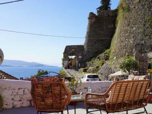 - une table et des chaises sur une terrasse avec vue sur l'océan dans l'établissement Saint george Hotel Parga, à Parga