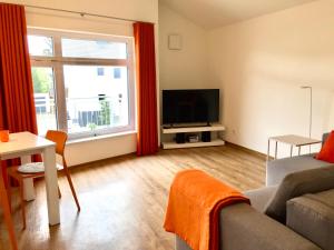 een woonkamer met een bank en een televisie bij aparthaus felizitas in Groß-Gerau
