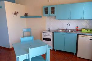 a kitchen with blue cabinets and a table and a sink at Appartamento Percebes. Stella Maris Exclusive in Calheta Do Maio