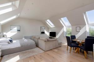a bedroom with a bed and a living room with skylights at The Loft - Rural setting with parking in Bishop Monkton