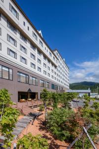 a large white building with a patio in front of it at Kiki Shiretoko Natural Resort in Shari