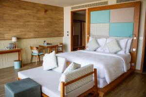 ein Schlafzimmer mit einem großen weißen Bett und einem Tisch in der Unterkunft Fusion Suites Vung Tau in Vũng Tàu