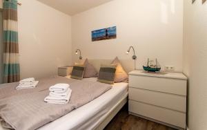 ein kleines Schlafzimmer mit einem Bett und einer Kommode in der Unterkunft An Bord - Steuerbord in Sankt Peter-Ording
