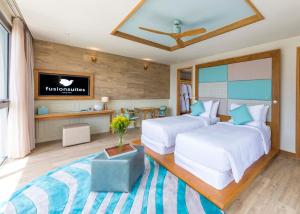 a hotel room with two beds and a television at Fusion Suites Vung Tau in Vung Tau