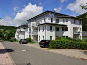 a white building with cars parked in front of it at Magnificent Apartment in Willingen with Balcony in Willingen