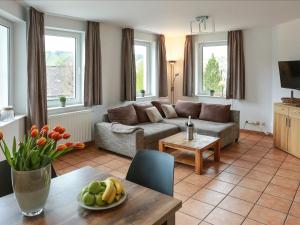 ein Wohnzimmer mit einem Sofa und einem Tisch in der Unterkunft Magnificent Apartment in Willingen with Balcony in Willingen