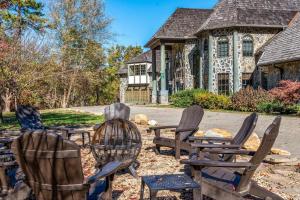 un groupe de chaises devant une maison dans l'établissement Mountain Bliss: Estate w/ Views~FirePit~Hot Tub~Gburg 5min~3 Pools, à Gatlinburg