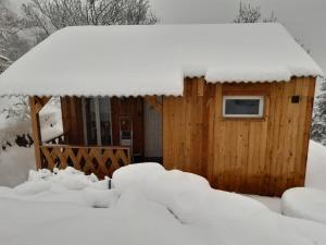 a wooden cabin in the snow with snow on it at chalet Le Géranium in Briançonnet