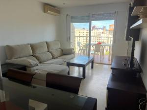 a living room with a couch and a table at Bitacora VI Solo Familias SERVIPLAYA in Playa de Gandia