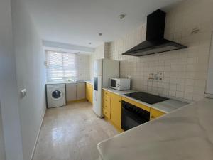 a kitchen with a sink and a washer and dryer at Bitacora VI Solo Familias SERVIPLAYA in Playa de Gandia