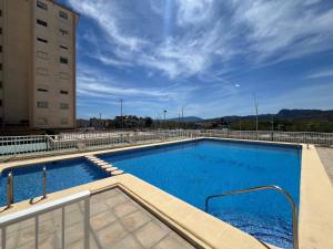 a large blue swimming pool next to a building at Bitacora VI Solo Familias SERVIPLAYA in Playa de Gandia