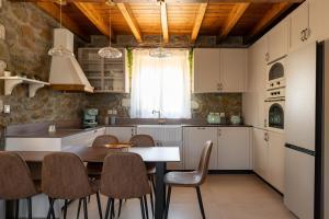 Una cocina con una mesa y sillas en una habitación. en Villa Roi, en Kalathos