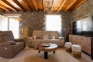 Una sala de estar con un sofá, una mesa y un televisor. en Villa Roi, en Kalathos