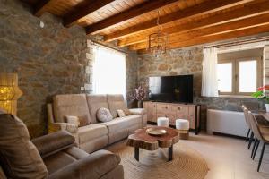 Una sala de estar con un sofá y un televisor. en Villa Roi, en Kalathos