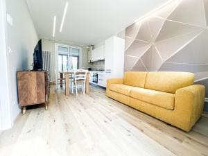 sala de estar con sofá amarillo y cocina en EQUILIO PARK, en Lido di Jesolo