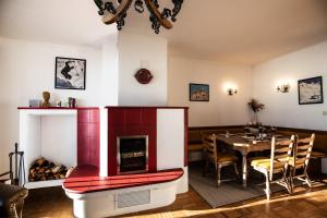 uma sala de jantar com uma lareira vermelha e uma mesa em Nockhaus76 - 70s GLAM in den Nockbergen - Almhaus auf 1560 m em Hochrindl