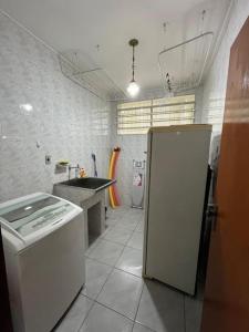 a small kitchen with a refrigerator and a sink at Chácara Santa Maria in Itupeva