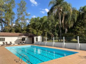a swimming pool in a yard with a palm tree at Chácara Santa Maria in Itupeva