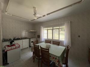 a kitchen with a table and chairs and a table and a window at Chácara Santa Maria in Itupeva