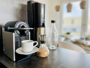 eine Kaffeetasse auf einer Theke neben einer Kaffeemaschine in der Unterkunft Albert Einstein Suite im Wissenschaftspark in Osnabrück