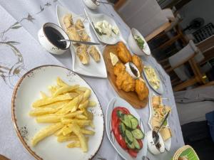 una mesa con platos de comida y patatas fritas en Two Brothers Valbone, en Valbonë