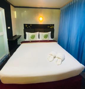 a bedroom with a large white bed with towels on it at Pakor Boutique Resort in Phangnga