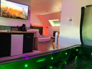 a bathroom with a bath tub with a tv on the wall at Domaine de la Besnerie Gites avec SPA Privatif à 10 min du Mont St Michel in Tanis