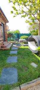 a garden with a table and a bench and grass at Tinyhouses am Neusiedlersee in Fertőrákos