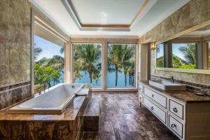 ein großes Bad mit zwei Waschbecken und einem großen Fenster in der Unterkunft Hon Tam Resort in Nha Trang