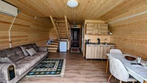 ein Wohnzimmer mit Sofa und eine Küche in der Unterkunft Time House in Kokotauri