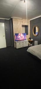 1 dormitorio con TV de pantalla plana en una cómoda en gms service, en Lorenskog