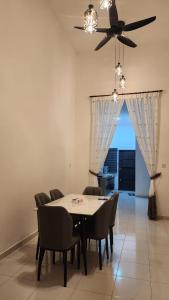 a dining room with a table and chairs and a ceiling fan at Masturi Homestay in Chemor