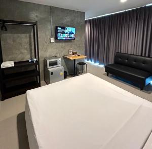 a bedroom with a bed and a couch and a tv at Udomsuk Inn & Cafe Since 2019 - BTS Udomsuk in Bangkok