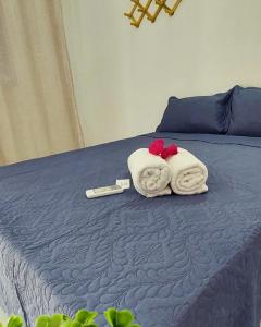 ein Bett mit zwei Handtüchern und einem Thermometer drauf in der Unterkunft JACY AP GOSTOSO in São Miguel do Gostoso