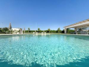 een groot zwembad met blauw water bij Terra Home Resort in Spongano