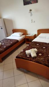 two beds in a hotel room with towels on them at Dardiza Stay in Ermioni