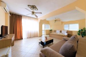 a living room with a couch and a tv at Hotel Angy in Golden Sands