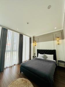 a bedroom with a large bed and large windows at RL Boutique Dalat in Da Lat